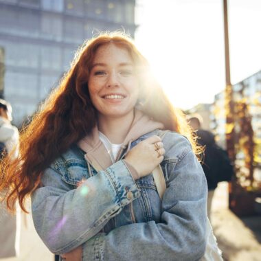 Girl smiling at camera with sun in background